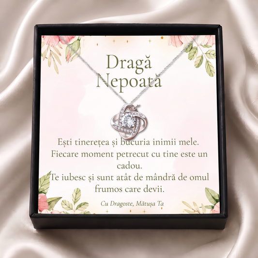 Cutie cadou neagră deschisă cu lănțișorul Nodul iubirii și cardul „Dragă Nepoată”, pe satin crem