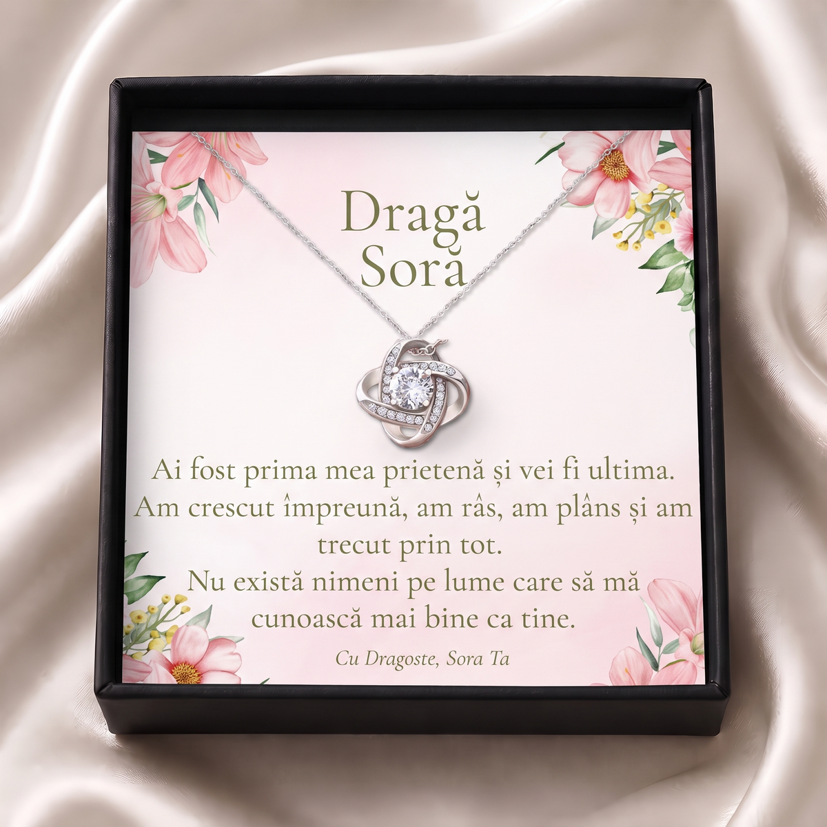 Cutie cadou neagră deschisă cu lănțișorul Nodul iubirii și cardul „Dragă Soră”, pe satin crem