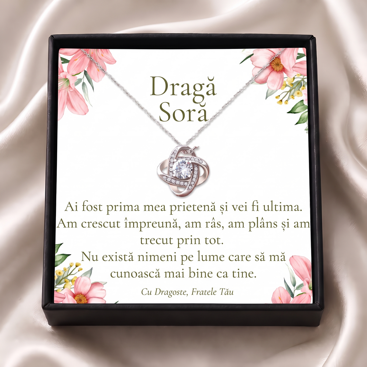 Cutie cadou neagră deschisă cu lănțișorul Nodul iubirii și cardul „Dragă Soră”, pe satin crem