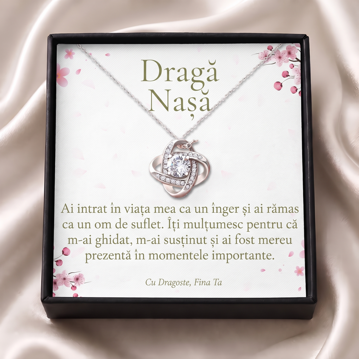 Cutie cadou neagră deschisă cu lănțișorul Nodul iubirii și cardul „Dragă Nașă”, pe satin crem