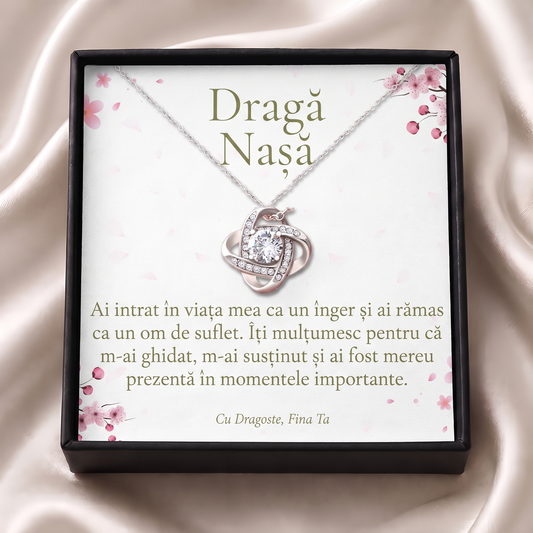 Cutie cadou neagră deschisă cu lănțișorul Nodul iubirii și cardul „Dragă Nașă”, pe satin crem